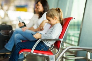 young girl playing with tablet pc at airport